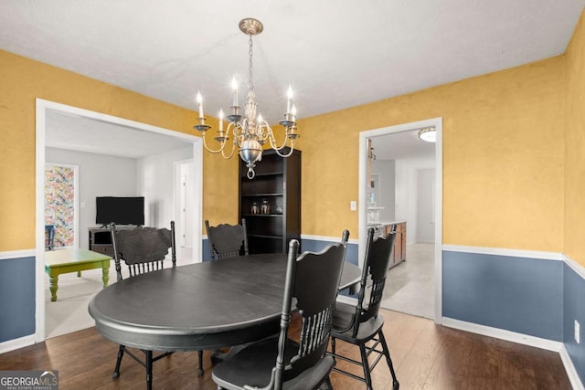 dining room with hardwood / wood-style flooring and a notable chandelier