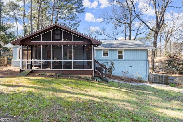 back of house featuring a sunroom and a yard