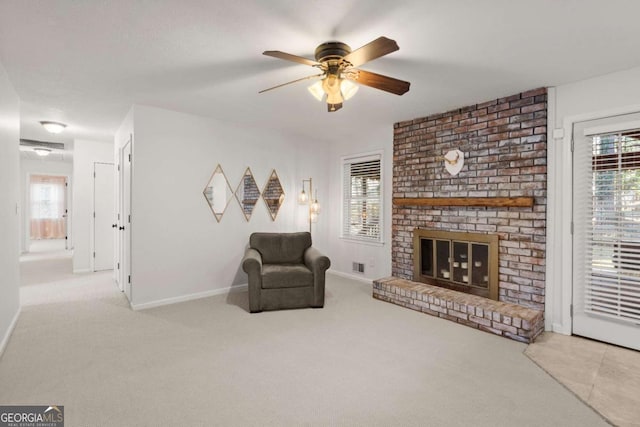 living room featuring a brick fireplace, light colored carpet, and ceiling fan