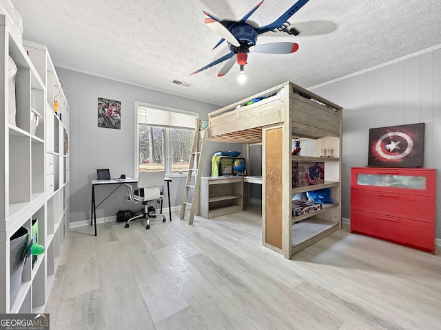 bedroom featuring crown molding, ceiling fan, hardwood / wood-style flooring, and a textured ceiling