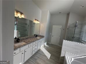 bathroom with vanity, an enclosed shower, and hardwood / wood-style floors