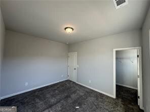 unfurnished bedroom featuring dark colored carpet