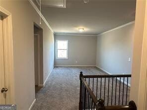 hallway with crown molding and carpet