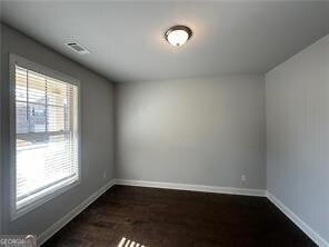 unfurnished room featuring dark hardwood / wood-style flooring