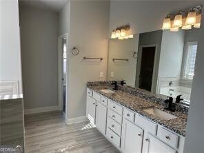 bathroom with a tub to relax in, vanity, and hardwood / wood-style floors