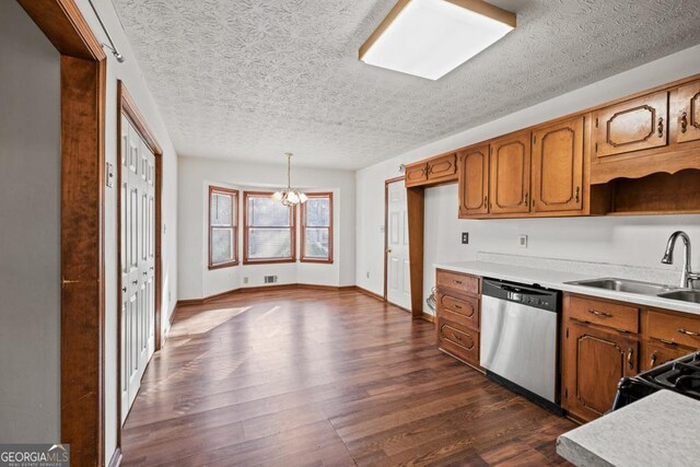 kitchen with sink, decorative light fixtures, a textured ceiling, stainless steel dishwasher, and dark hardwood / wood-style floors