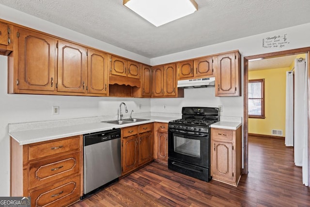 kitchen with sink, dark wood-type flooring, black range with gas cooktop, a textured ceiling, and stainless steel dishwasher