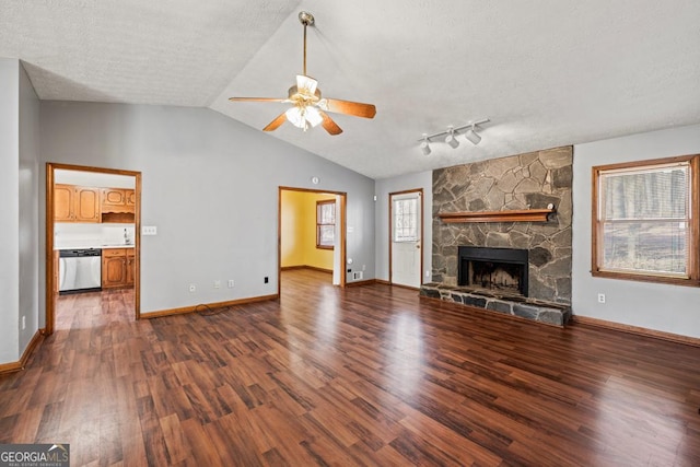 unfurnished living room featuring lofted ceiling, dark wood-type flooring, a fireplace, and a textured ceiling