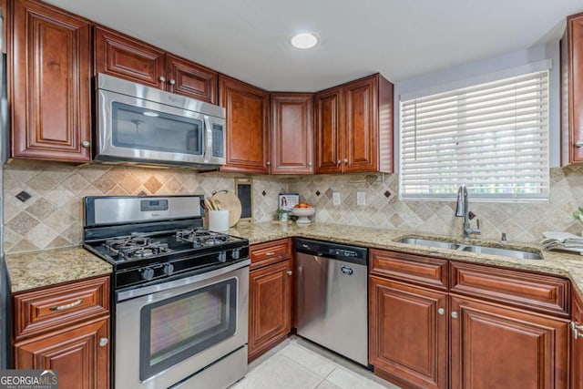 kitchen featuring sink, light tile patterned floors, light stone countertops, and appliances with stainless steel finishes