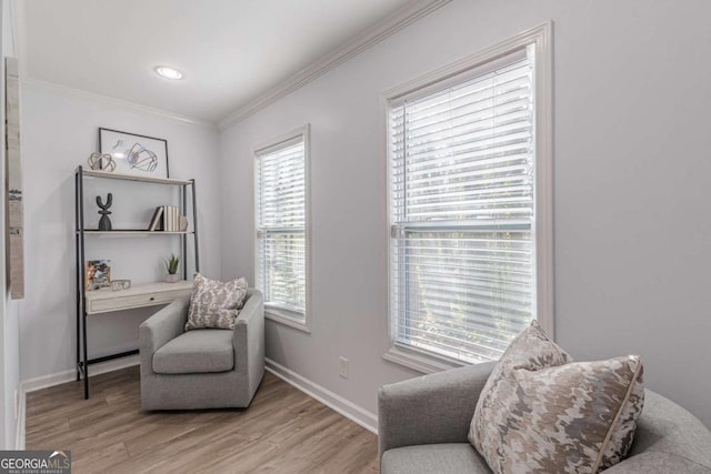 sitting room featuring ornamental molding and light wood-type flooring