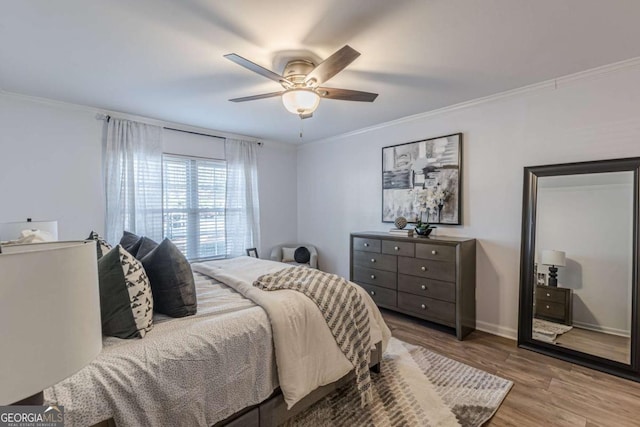 bedroom with crown molding, light hardwood / wood-style floors, and ceiling fan