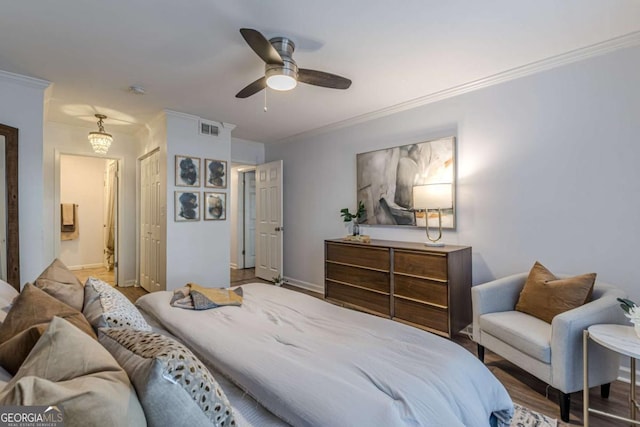 bedroom with hardwood / wood-style flooring, crown molding, ensuite bathroom, and ceiling fan