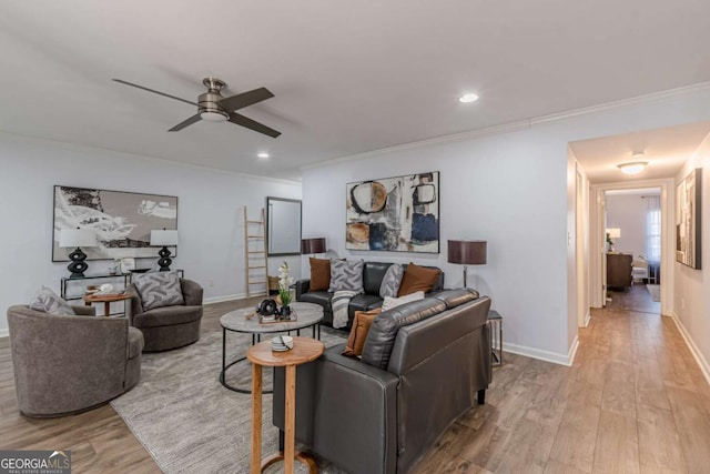 living room featuring ceiling fan, ornamental molding, and light hardwood / wood-style floors