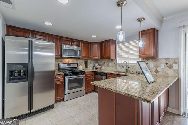 kitchen featuring appliances with stainless steel finishes, decorative light fixtures, sink, light stone counters, and kitchen peninsula