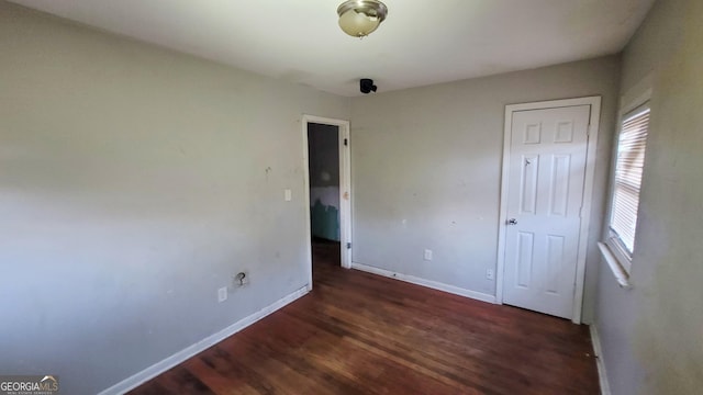 unfurnished bedroom with dark hardwood / wood-style flooring