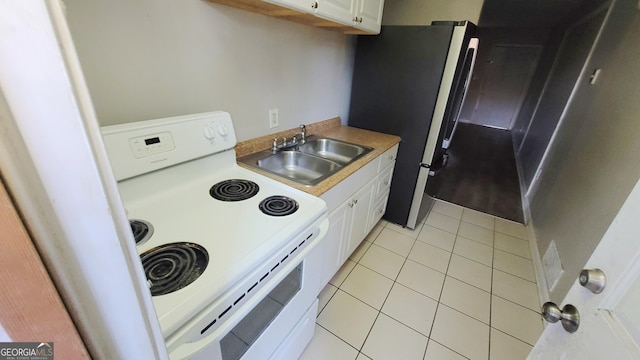 kitchen with light tile patterned flooring, sink, white cabinetry, stainless steel fridge, and white electric stove