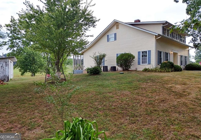 view of property exterior with central AC and a yard