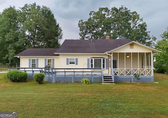 rear view of house featuring a deck and a lawn