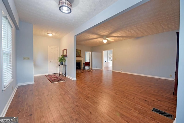 foyer featuring ceiling fan, wood-type flooring, and a textured ceiling