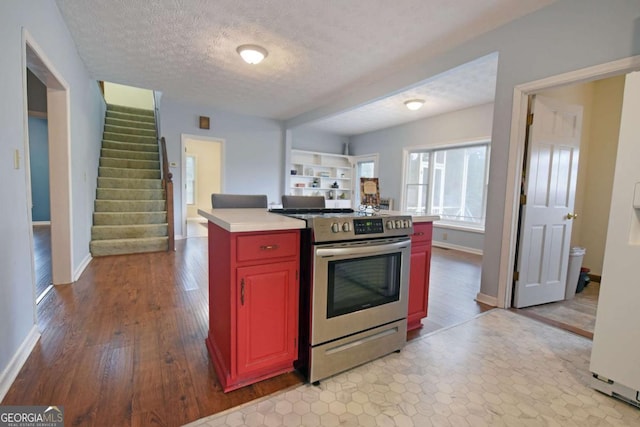 kitchen featuring a center island, light hardwood / wood-style floors, stainless steel stove, and a textured ceiling