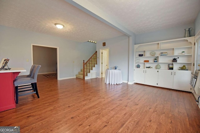 living room with a textured ceiling and light wood-type flooring