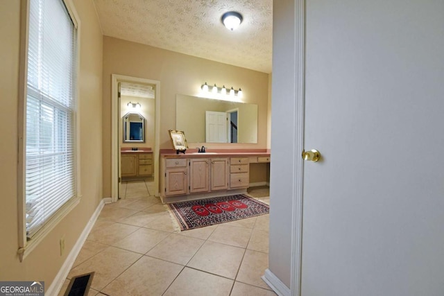 bathroom with tile patterned flooring, vanity, and a textured ceiling