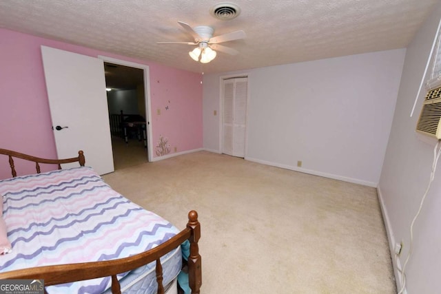 carpeted bedroom with ceiling fan, a closet, and a textured ceiling