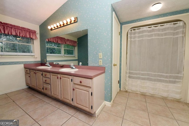 bathroom with lofted ceiling, vanity, tile patterned floors, and a textured ceiling