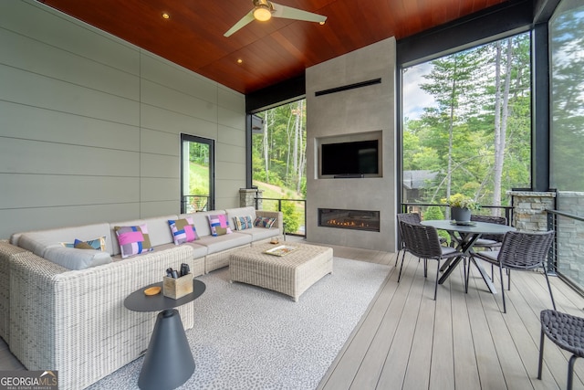 sunroom with wood ceiling, ceiling fan, and a fireplace