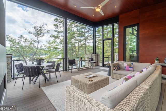 sunroom featuring ceiling fan, wooden ceiling, and a healthy amount of sunlight