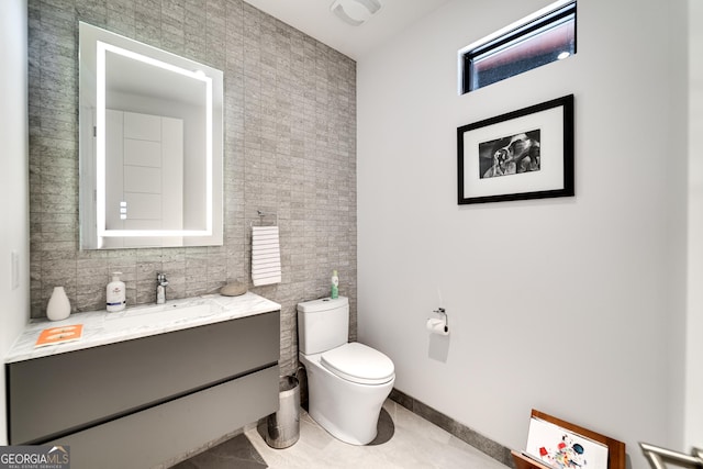 bathroom with vanity, tile patterned floors, tile walls, and toilet