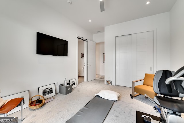 exercise room with ceiling fan and carpet