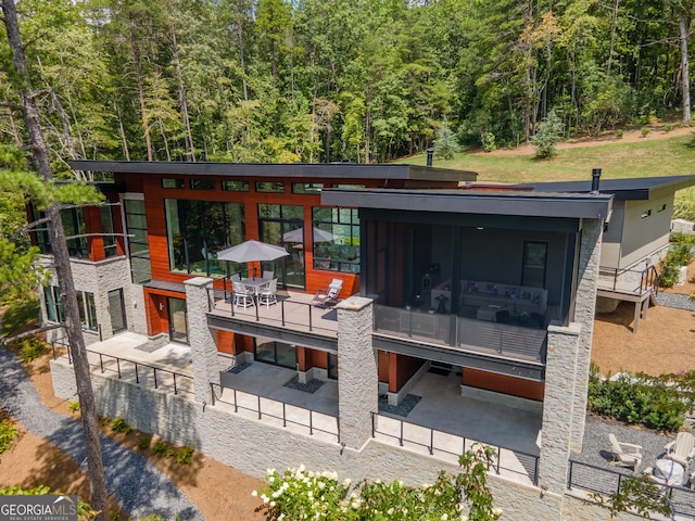 rear view of house with a sunroom and a patio area