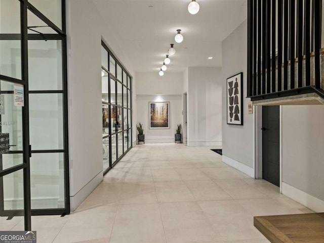 hallway featuring floor to ceiling windows and light tile patterned floors