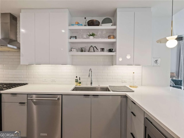 kitchen with wall chimney exhaust hood, sink, stainless steel dishwasher, decorative backsplash, and white cabinets