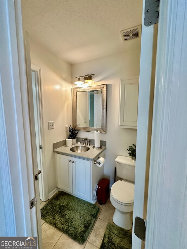 bathroom with vanity, tile patterned floors, a textured ceiling, and toilet