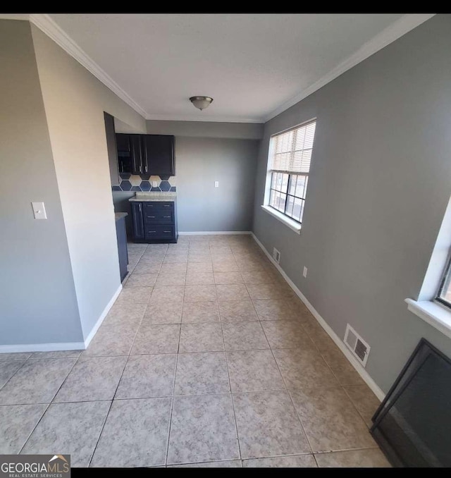 interior space with ornamental molding and light tile patterned floors