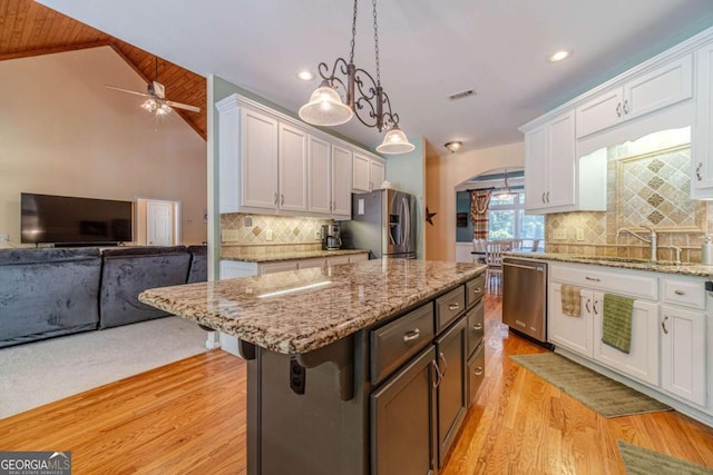 kitchen featuring a kitchen island, a breakfast bar, white cabinets, and appliances with stainless steel finishes