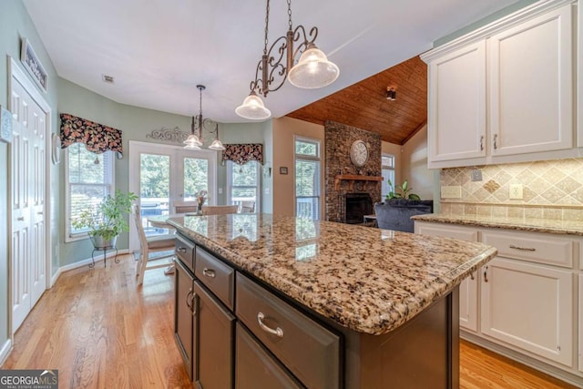 kitchen featuring white cabinetry, a kitchen island, pendant lighting, and light wood-type flooring