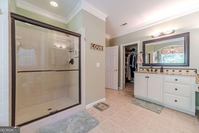 bathroom featuring ornamental molding, tile patterned flooring, a shower with door, and vanity