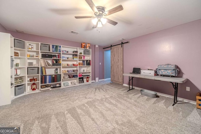 office with ceiling fan, a barn door, and carpet flooring