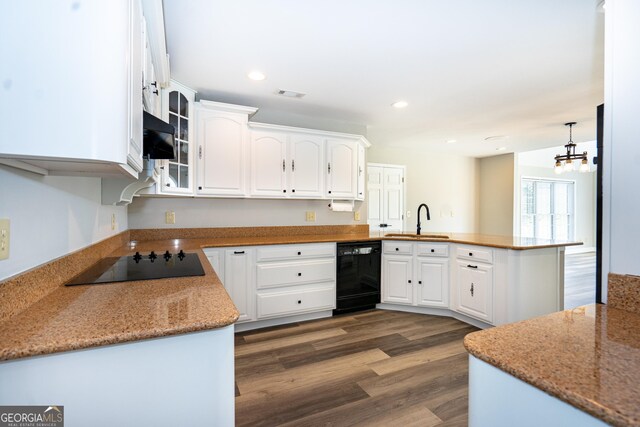 kitchen with sink, black appliances, kitchen peninsula, and white cabinets