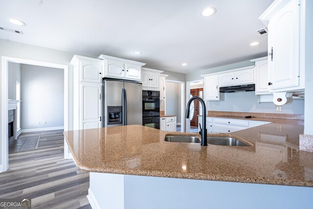 kitchen featuring white cabinets, stainless steel fridge, and stone counters