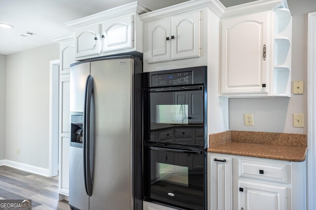 kitchen with white cabinetry, stainless steel refrigerator with ice dispenser, double oven, and light hardwood / wood-style flooring