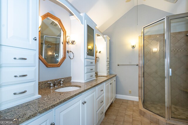 bathroom with vanity, lofted ceiling, and an enclosed shower