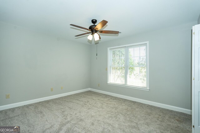 spare room with ceiling fan and light colored carpet