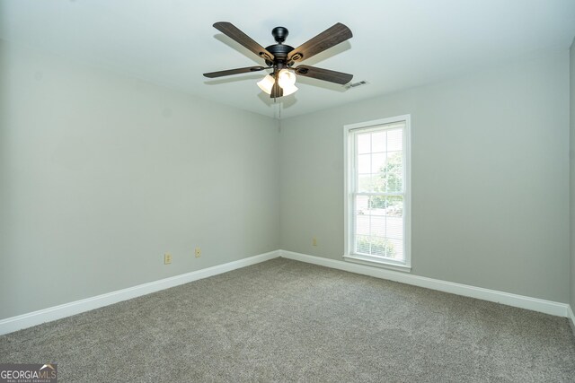 spare room with ceiling fan and carpet