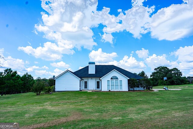 rear view of property with a yard