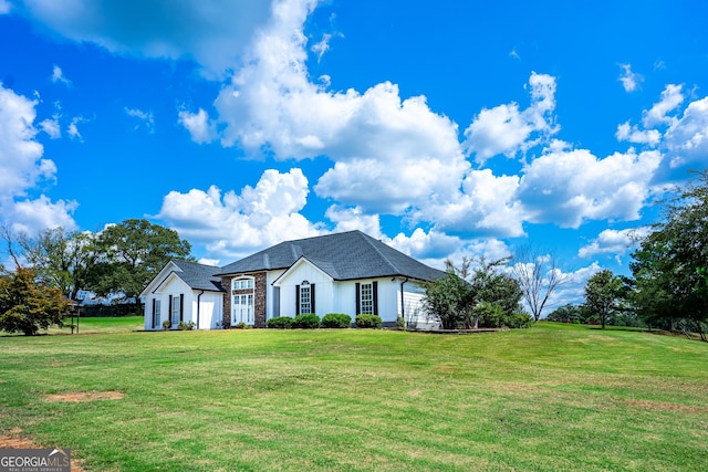 view of front of property featuring a shingled roof and a front yard