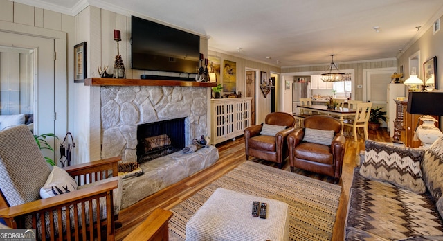 living room featuring crown molding, wood-type flooring, and a fireplace